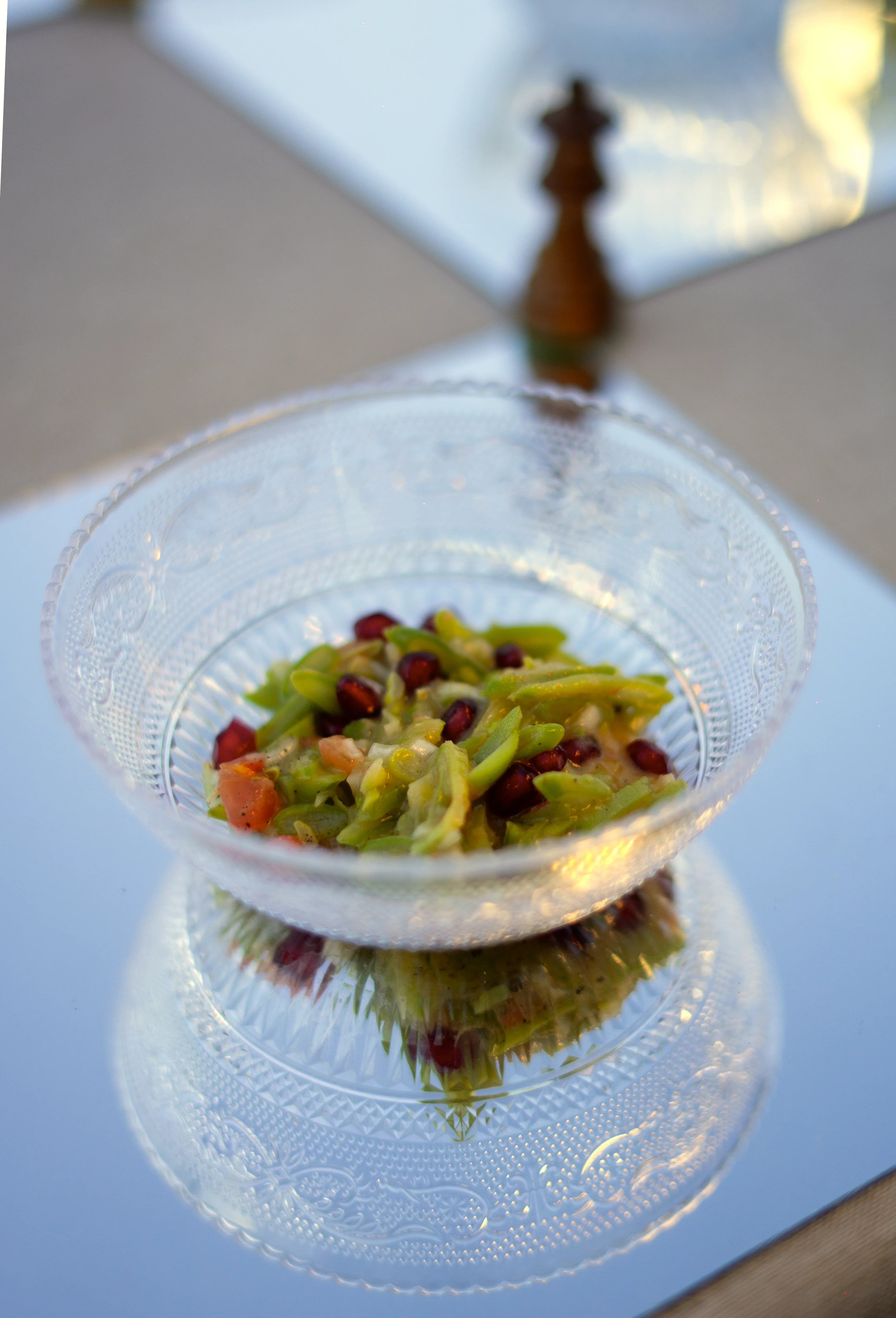 Ensalada fresca con granos de granada en bol de cristal