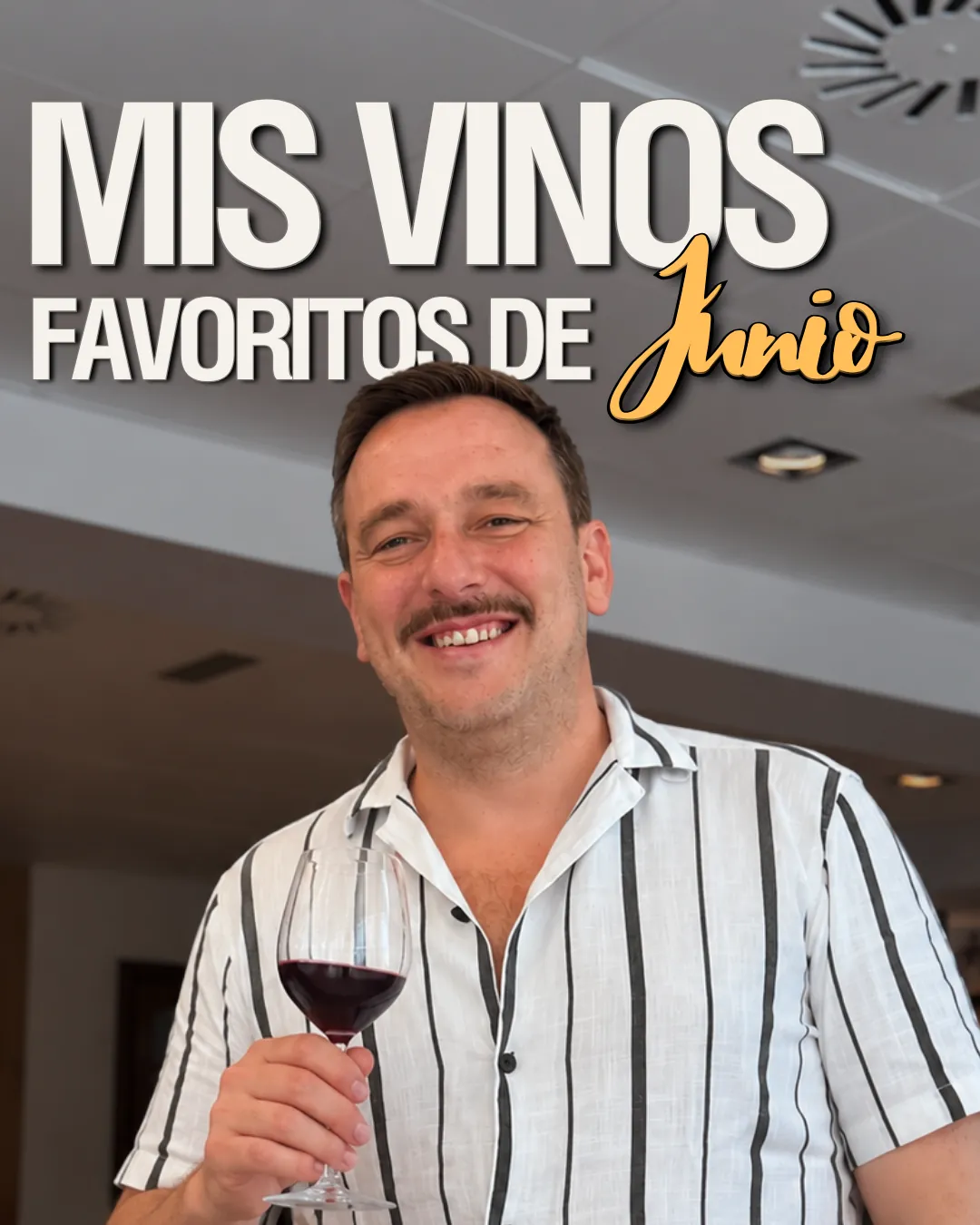 Pablo Teipro sonriendo en primer plano con una camisa blanca de rayas negras verticales y sosteniendo una copa de vino tinto