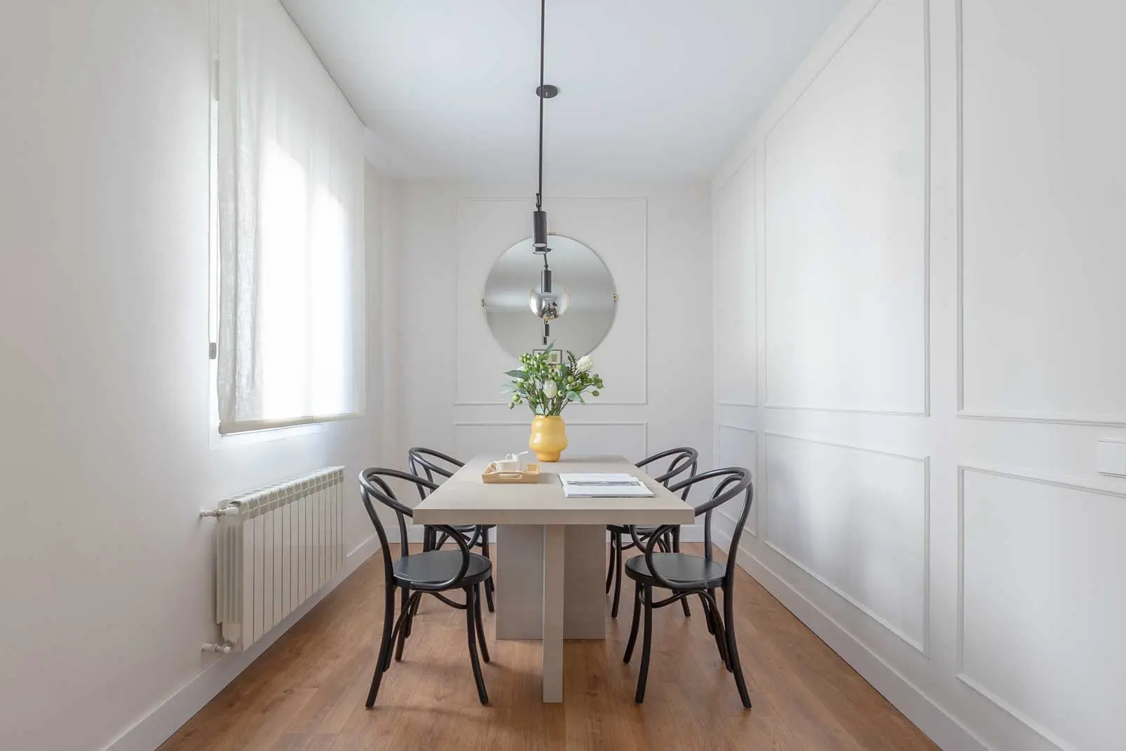 Cocina contemporánea con muebles blancos, frente de azulejos verde botella brillante y una zona de comedor diario con mesa redonda y papel pintado geométrico.