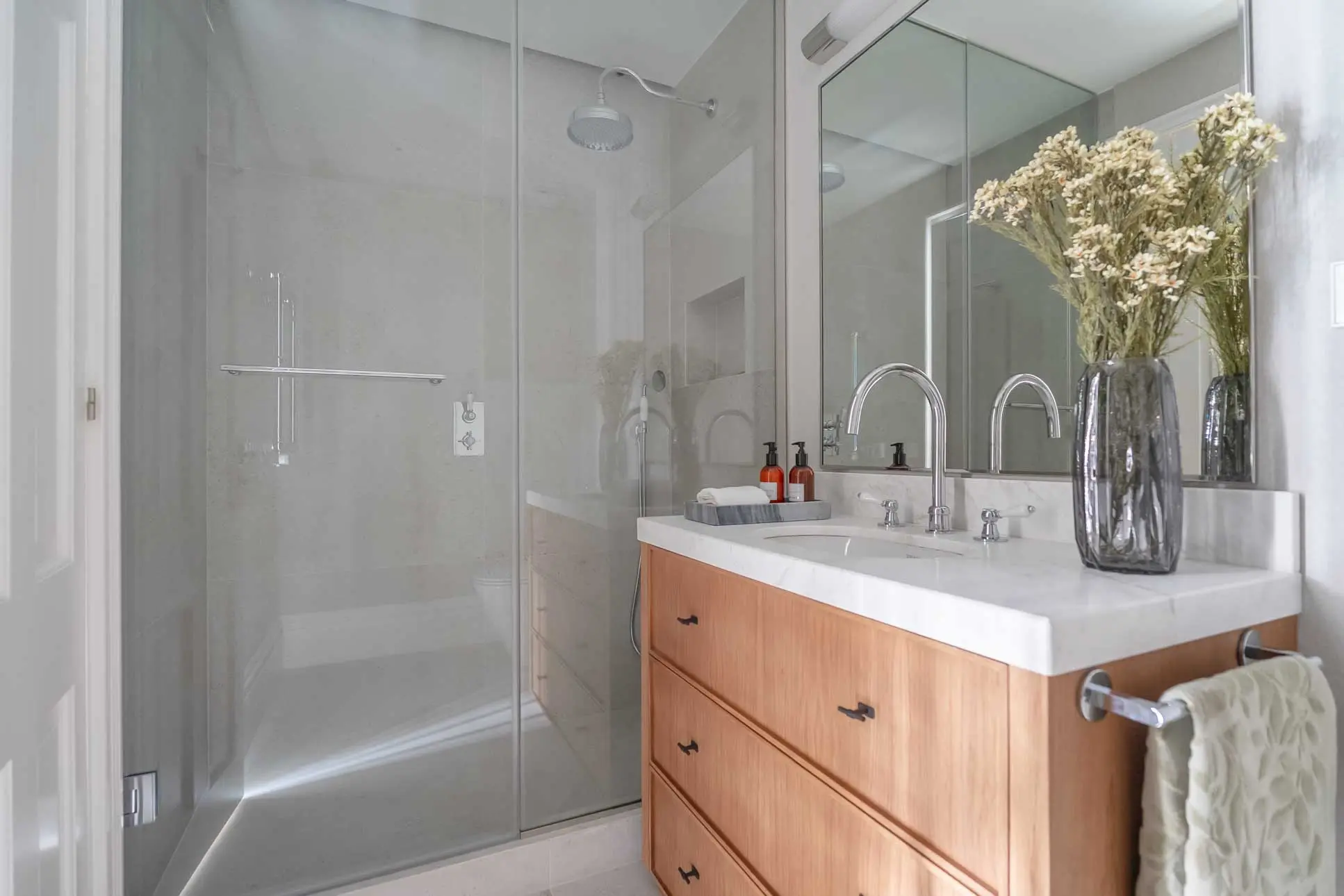 Cuarto de baño de diseño con acabados pulidos en mármol y grifería moderna