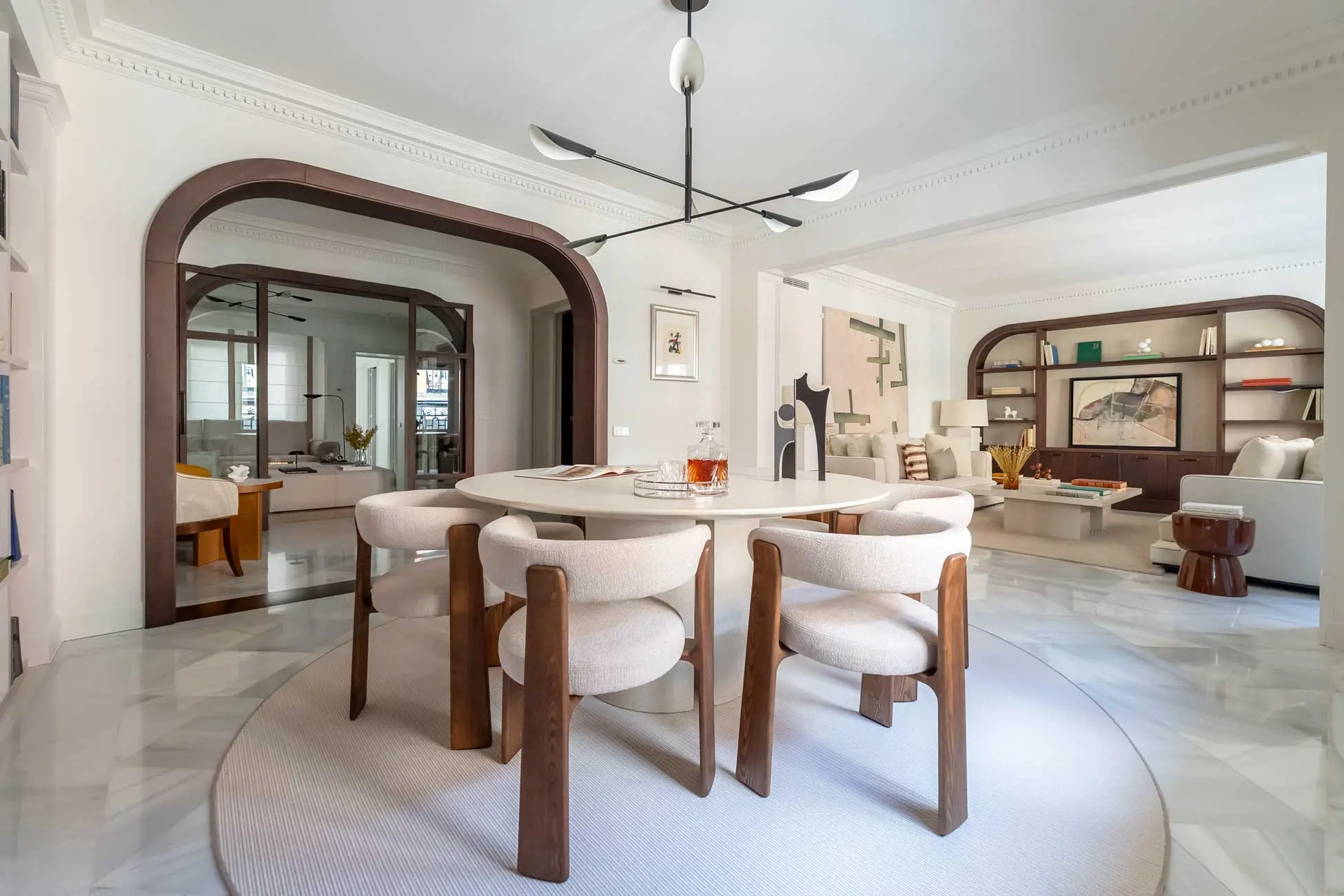 Salón comedor de lujo con diseño contemporáneo, inmobiliario vanguardista y amplios ventanales inundados de luz natural en el apartamento Academia de Madrid
