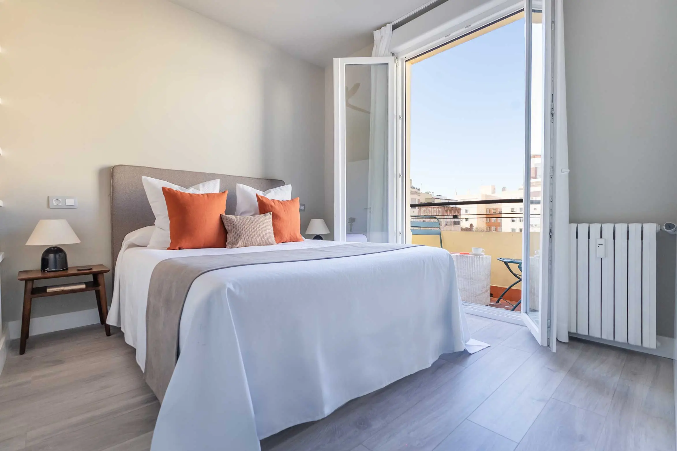 Dormitorio principal con acceso directo a la terraza exterior y sutiles toques de color naranja