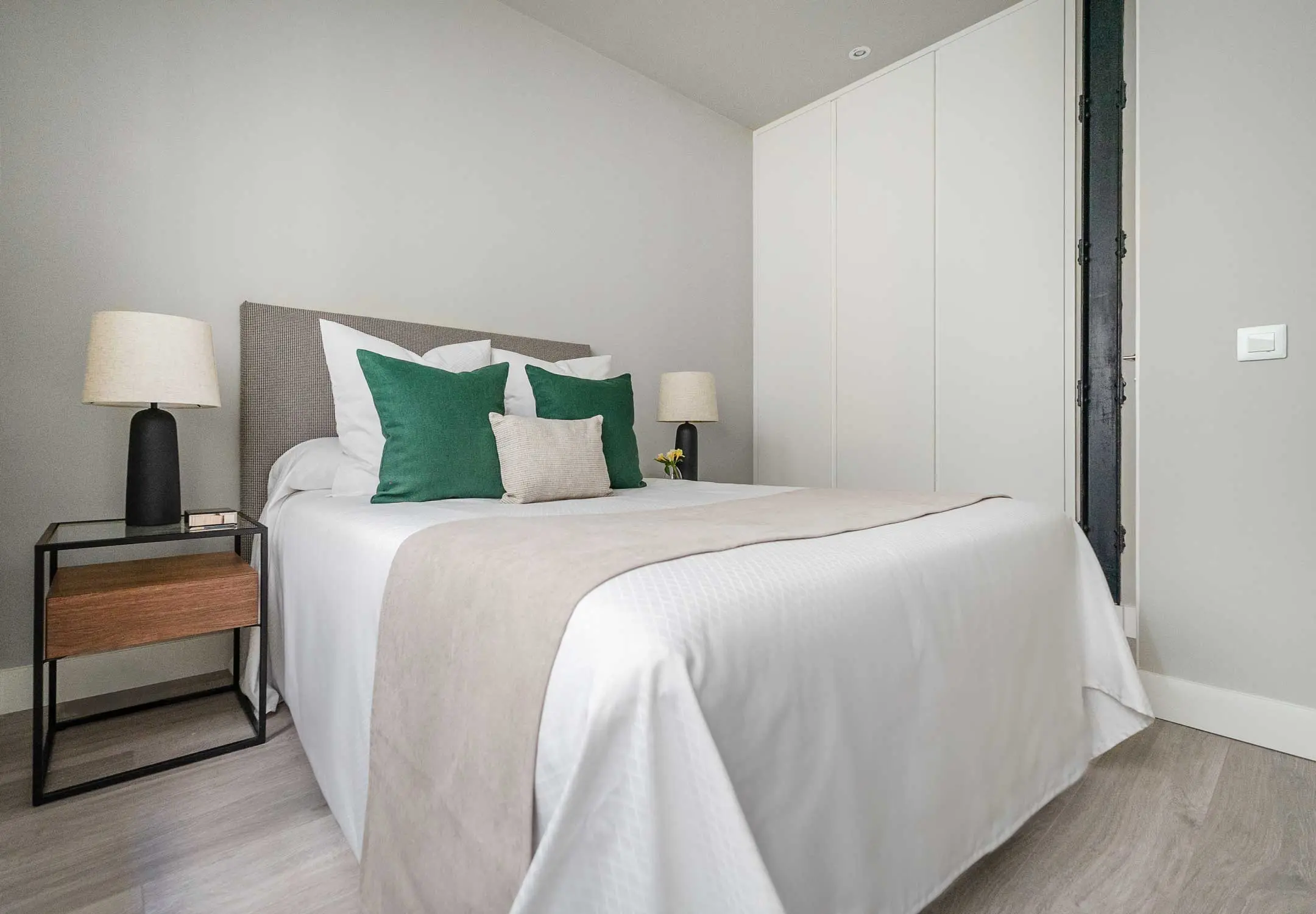 Segundo dormitorio con estilismo textil en tonos verdes y mesillas de noche minimalistas
