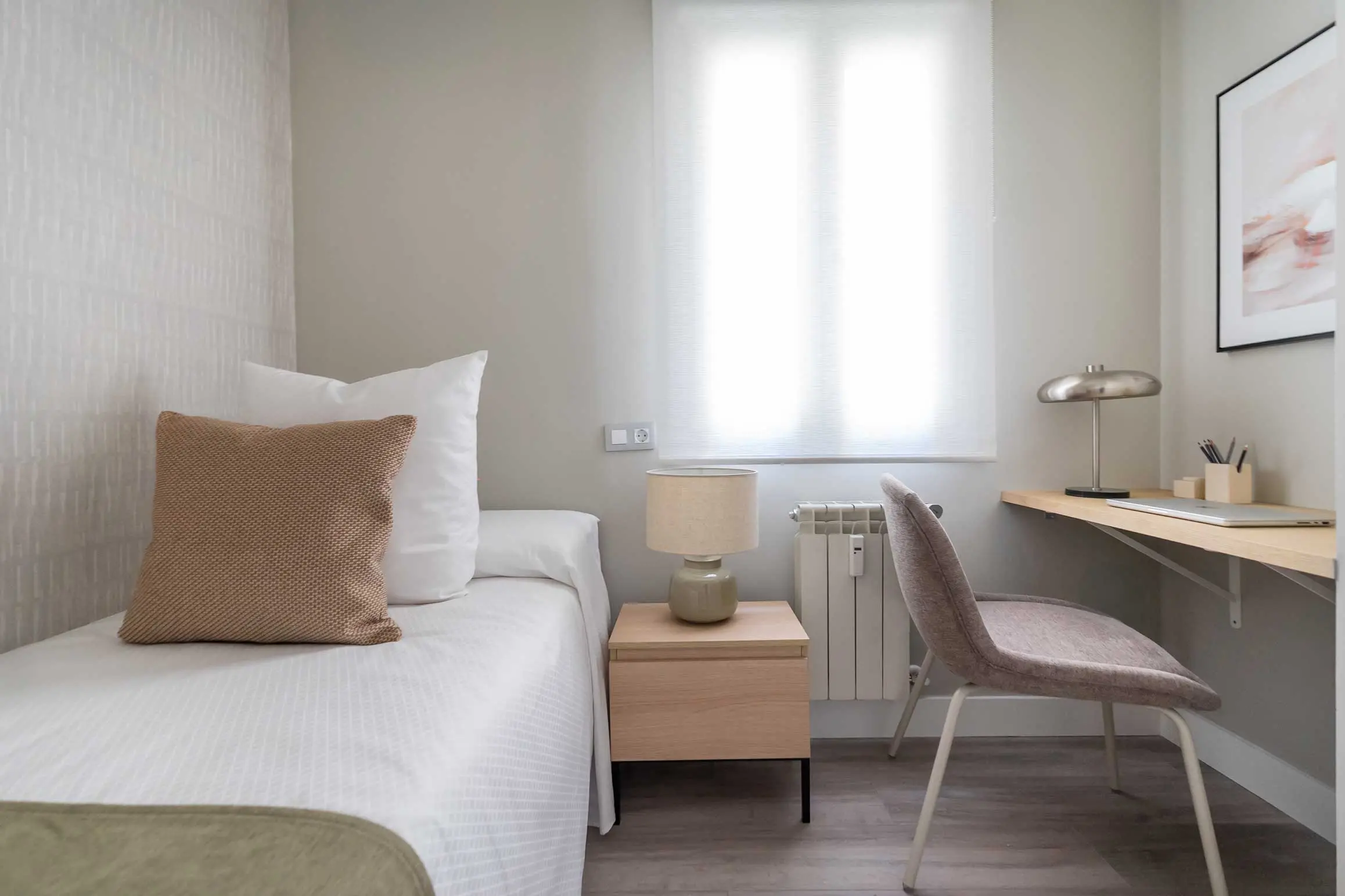 Habitación individual configurada como despacho y zona de estudio con escritorio de madera clara