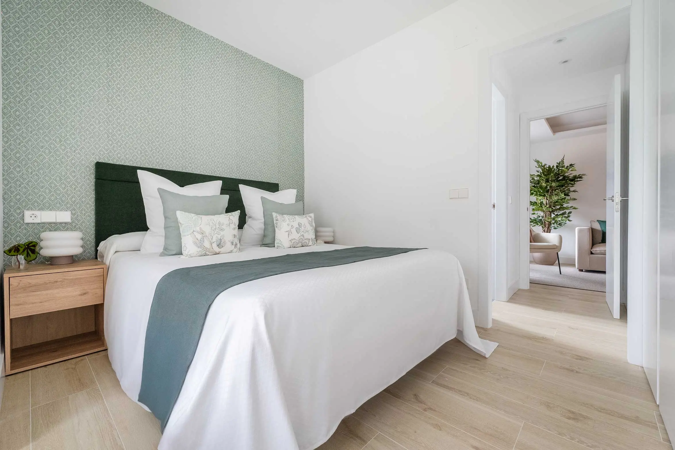 Ángulo amplio del dormitorio doble que muestra el paso fluido de luz natural hacia el pasillo de la vivienda