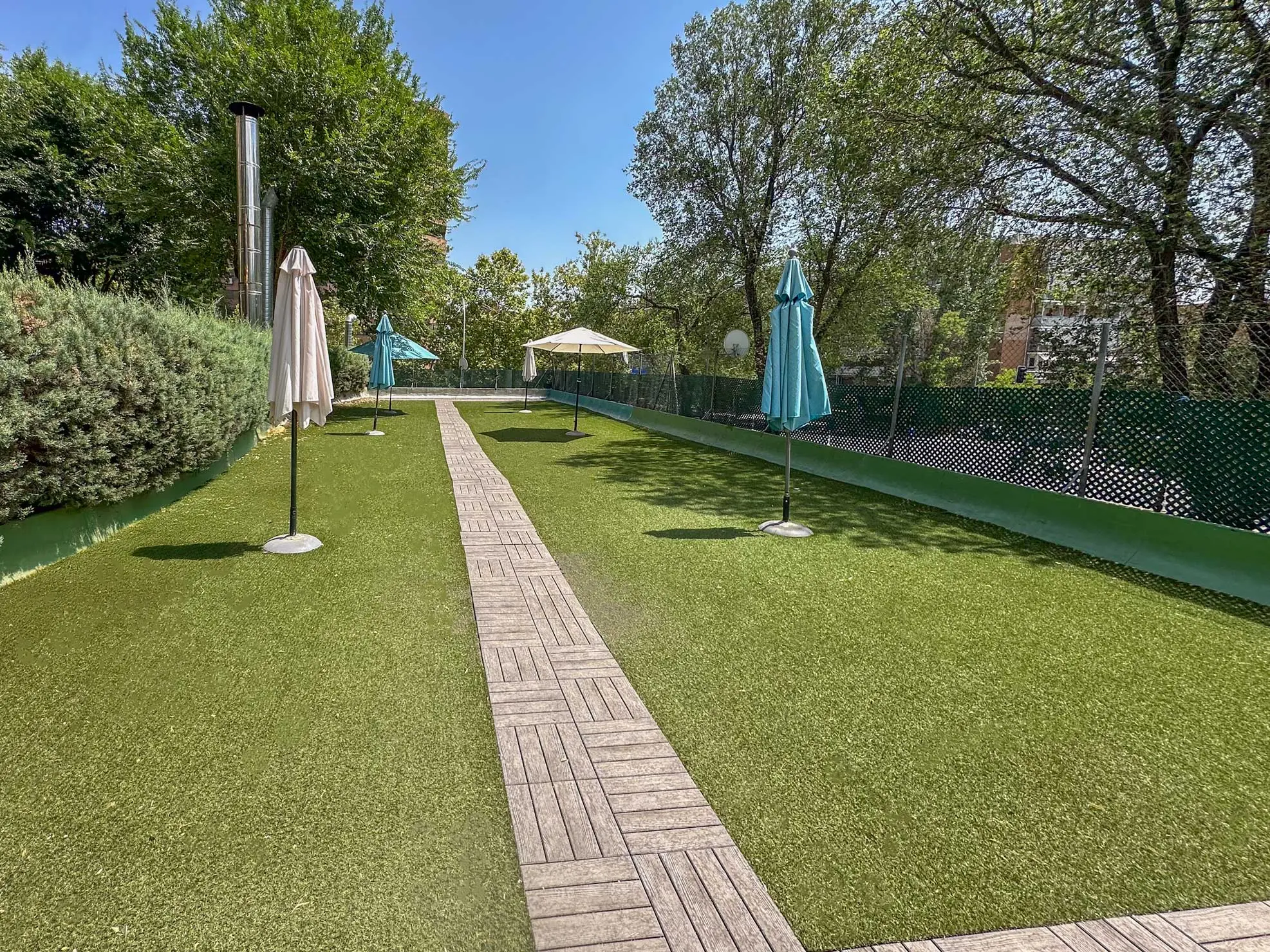Perspectiva alternativa de la piscina residencial mostrando las escaleras de caracol y el entorno arbolado