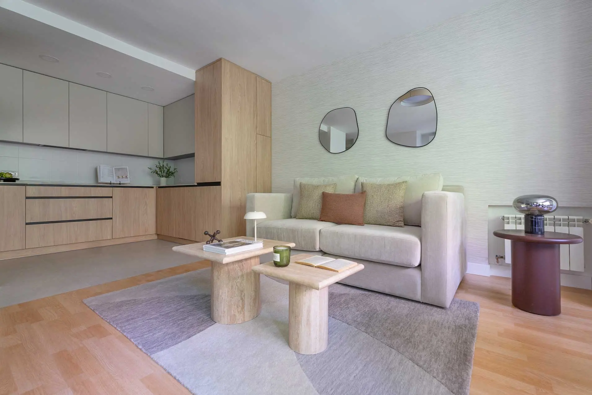 Ángulo lateral que integra la zona de estar del salón con los módulos de almacenamiento de madera de la cocina
