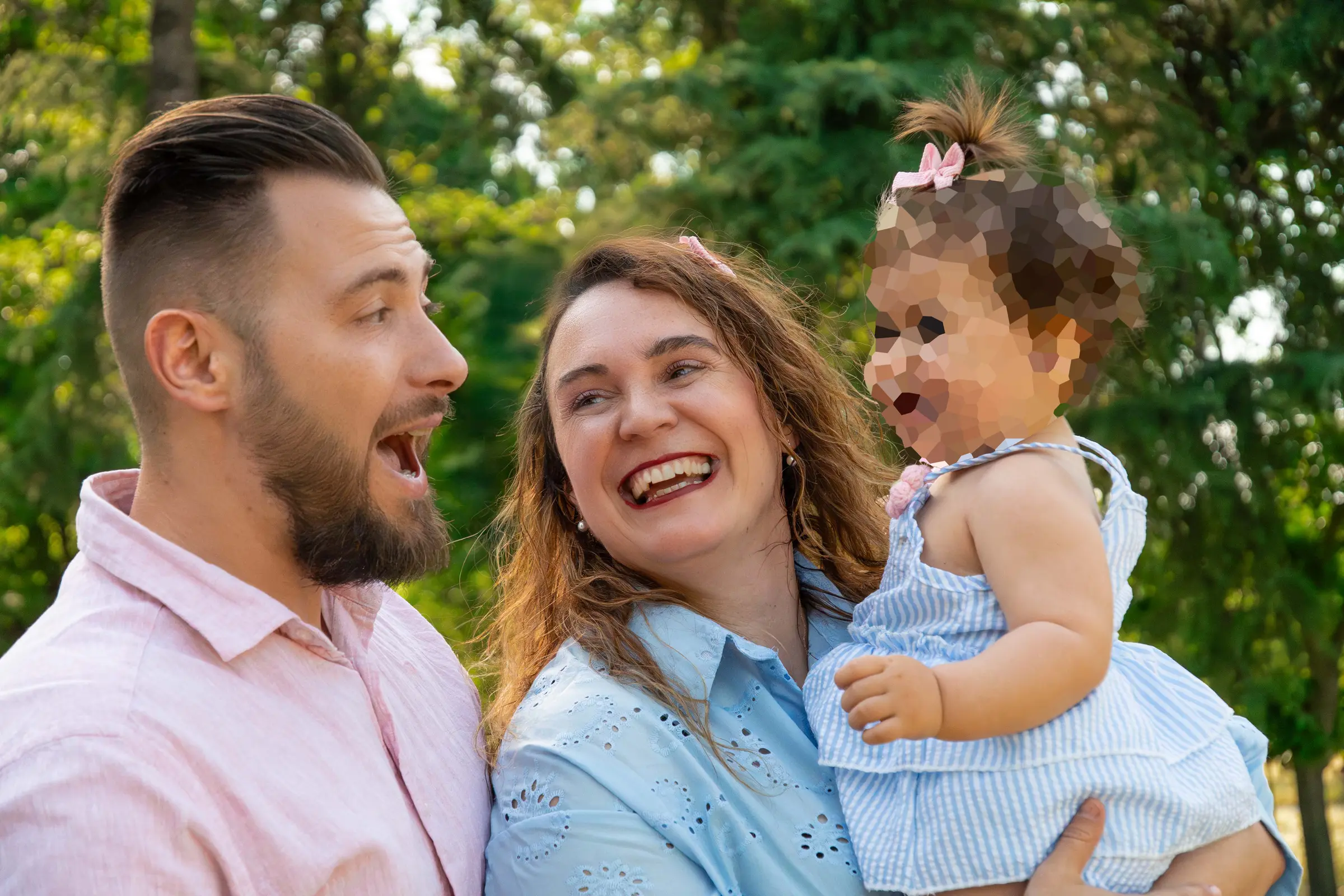 Primer plano de la madre riendo de felicidad junto a la carita de su hija en un momento espontáneo.